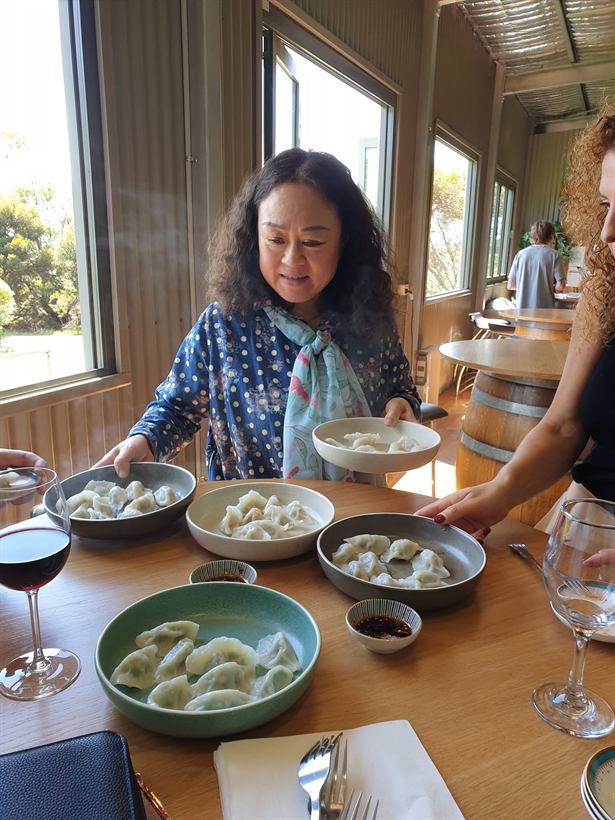 Wei serving plates of dumplings to guests
