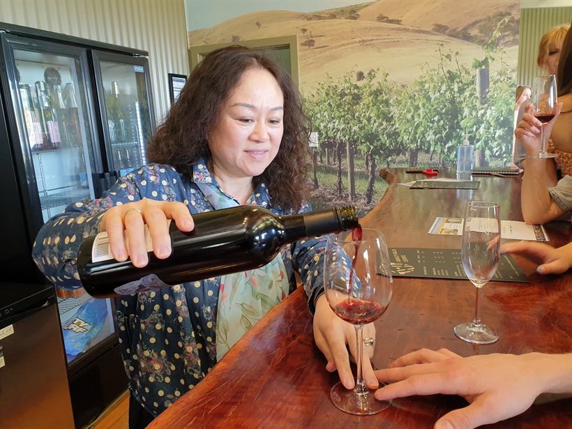 Wei pouring red wine into tasting glasses